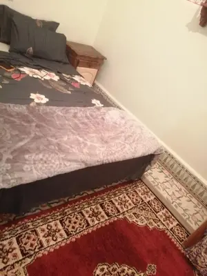 a bedroom with a bed with a red rug at Grand appartement à 3 minutes de la place jamaa el fana in Marrakech