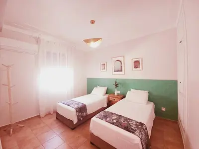 two beds in a room with green and white walls at Design Elegant Appartement in Marrakech