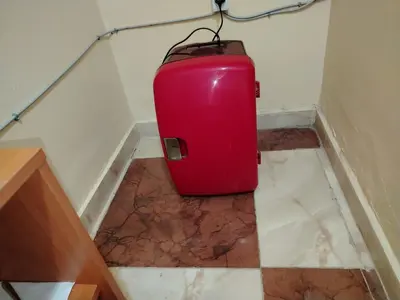 a red suitcase sitting in the corner of a room at غرفة مريحة و نضيفة in Marrakech