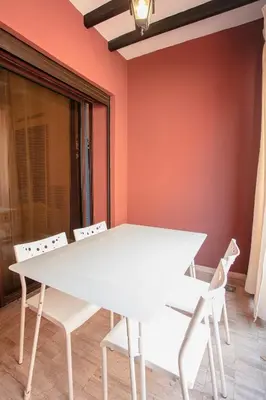 a white table and chairs in a room with orange walls at Traditionnel Boutique - Marrakech Downtown in Marrakech