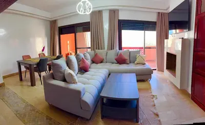 a living room with a couch and a table at appartement bel vue sur l'atlas in Marrakech