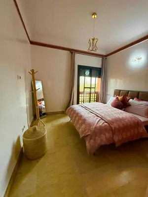 a bedroom with a large bed and a window at appartement bel vue sur l'atlas in Marrakech