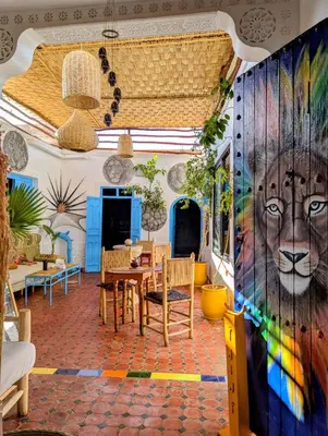 a dining room with a mural of a lion on the wall at Mandalahome in Marrakech