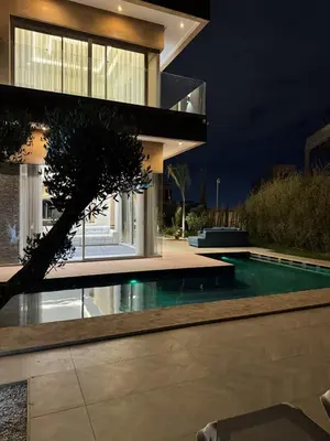 a house with a swimming pool at night at Villa Maymouna in Marrakech