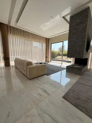 a large living room with a couch and a fireplace at Villa Maymouna in Marrakech