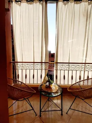 two chairs and a table in front of a window at Appartement cosy Marrakech in Marrakech