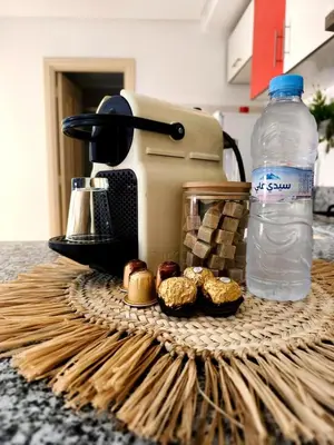 a table with a blender and some donuts and a bottle of water at Appartement cosy Marrakech in Marrakech