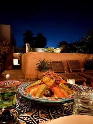 a table with a plate of food on it at Momo House- Riad Momo in Marrakech