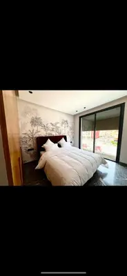 a bedroom with a large white bed with a window at Duplex haut standing in Marrakech