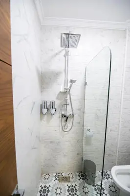a white bathroom with a shower and a sink at Jawhar Appart A4 in Marrakech
