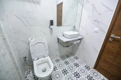 a white bathroom with a toilet and a sink at Jawhar Appart A4 in Marrakech