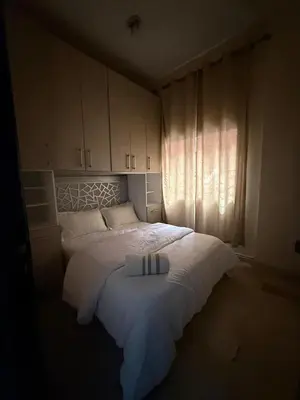 a bedroom with a bed with white sheets and a window at Modern studio near the center in Marrakech