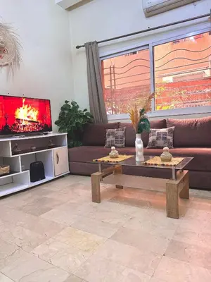 a living room with a couch and a tv at Modern studio near the center in Marrakech