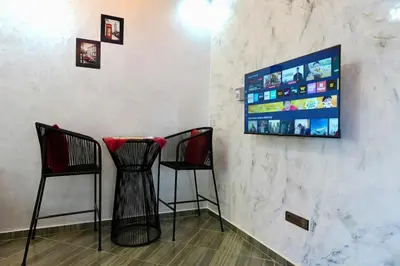 a bar with two chairs and a tv on a wall at good Appartement Marrakech in Marrakech