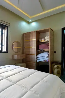 a bedroom with a large white bed and a closet at good Appartement Marrakech in Marrakech