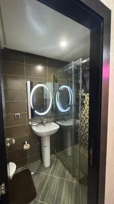 a bathroom with a sink and two mirrors at good Appartement Marrakech in Marrakech