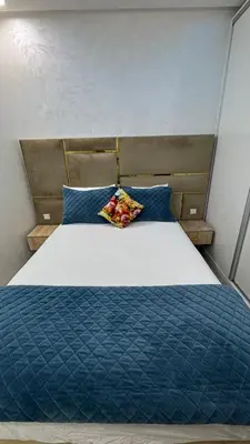 a bed with a blue comforter and blue pillows at Le Joyau de la Ville in Marrakech