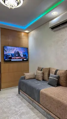 a living room with a couch and a flat screen tv at Le Joyau de la Ville in Marrakech