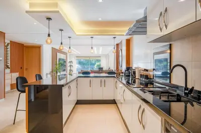 a large kitchen with white cabinets and black counter tops at M REVASION Elegant Luxury Stays in the Center of Marrakech in Marrakech
