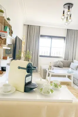 a living room with cups and saucers on a table at Appartement Cosy Majorelle au Centre-Ville - Netflix-Fibre in Marrakech