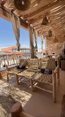 a porch with two benches and a view of the ocean at Appartement avec terrasse XXL in Marrakech