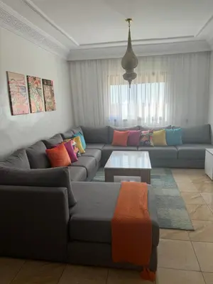 a living room with a couch and a table at GHIZLAN Apartment in Marrakech