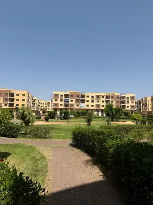 a brick path in a park with buildings in the background at GHIZLAN Apartment in Marrakech