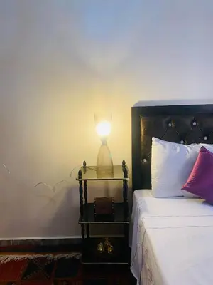 a lamp sitting on a table next to a bed at Dar béa in Marrakech