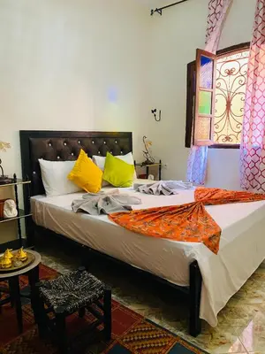 a bedroom with a large bed with yellow pillows at Dar béa in Marrakech