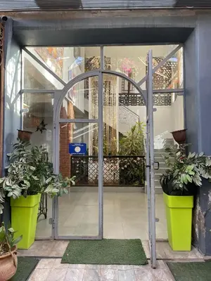 an open glass door with potted plants in it at MSC Hostel in Marrakech
