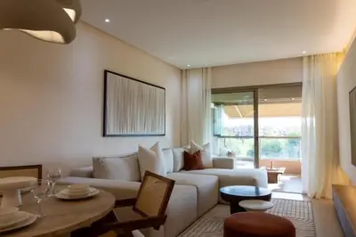 a living room with a white couch and a table at Appartement Sweet Home Marrakech in Marrakech