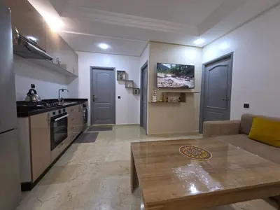 a kitchen and a living room with a couch and a table at Fabuleux appartement au centre ville de Marrakech à Gueliz Gare CTM et Train in Marrakech