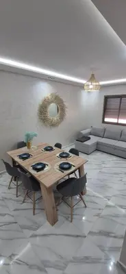 a living room with a wooden table and a couch at Havre de paix en plein Marrakech in Marrakech