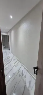 a room with a white wall with a marble floor at Havre de paix en plein Marrakech in Marrakech