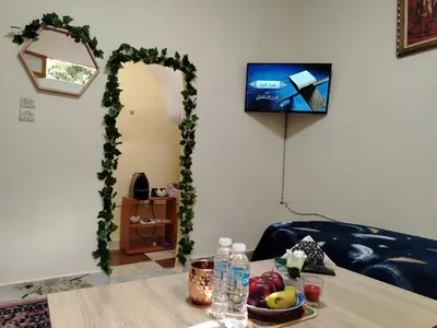 a living room with a table and a arch with a television at غرفه هادئه في موقع رائع وقريبه من كولشي in Marrakech
