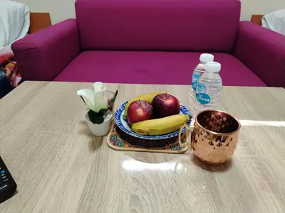 a table with a bowl of fruit and a bottle of water at غرفه هادئه في موقع رائع وقريبه من كولشي in Marrakech