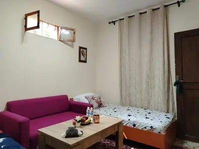 a living room with a purple couch and a table at غرفه هادئه في موقع رائع وقريبه من كولشي in Marrakech