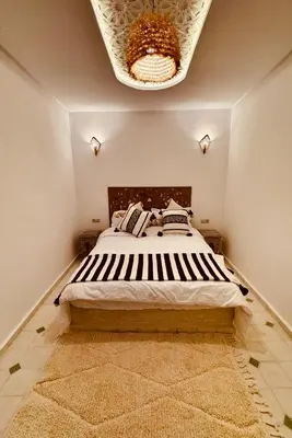 a bedroom with a large bed with a chandelier at Riad Kimee Room 3 in Marrakech