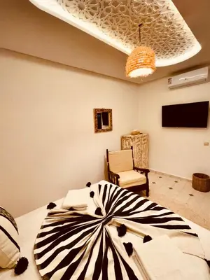 a zebra print bed in a room with a chair at Riad Kimee Room 3 in Marrakech