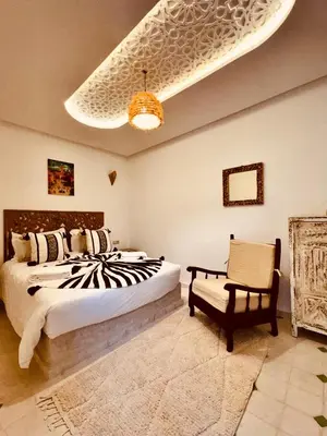 a bedroom with a large bed and a chair at Riad Kimee Room 3 in Marrakech