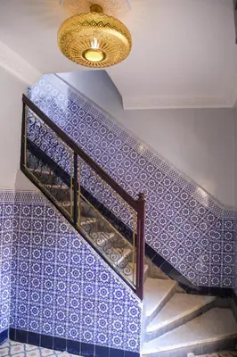 a staircase with blue tiles and a chandelier at Riad Authentique en Exclusivité in Marrakech