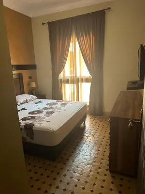 a bedroom with a bed and a large window at Appartement PREMIUM VILLAGE in Marrakech