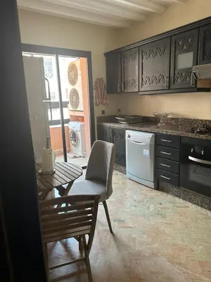 a kitchen with a table and a chair in it at Appartement PREMIUM VILLAGE in Marrakech