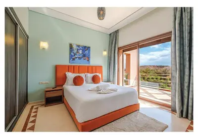 a bedroom with a large bed and a balcony at Villa Pivoine avec Jacuzzi, Cuisinière, Piscine in Marrakech