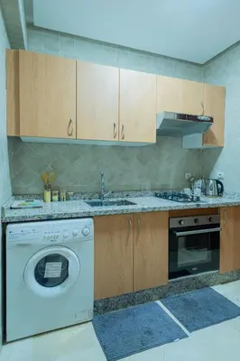 a kitchen with a washing machine and a sink at Charment et spacieux 2 chambres avec salon in Marrakech