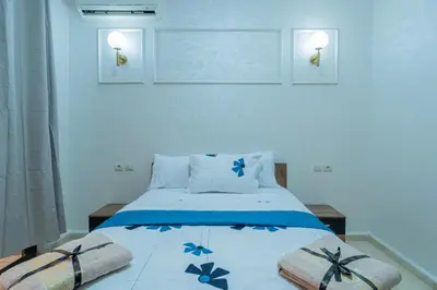 a bedroom with a bed with blue flowers on it at Charment et spacieux 2 chambres avec salon in Marrakech