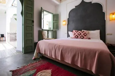 a bedroom with a large bed with a black headboard at Riad Akhdar Kasbah Breakfast included in Marrakech