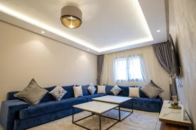 a living room with a blue couch and a table at Stylish Apartment Heart of Gueliz Netflix in Marrakech
