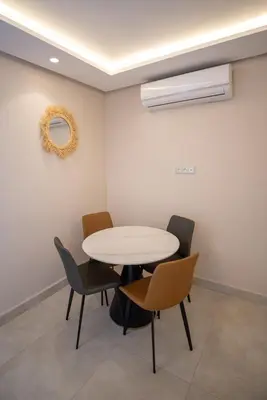 a dining room with a white table and chairs at Stylish Apartment Heart of Gueliz Netflix in Marrakech