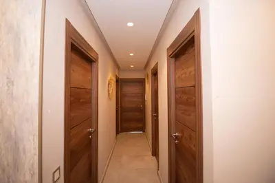 a hallway with two wooden doors and a walkway at Stylish Apartment Heart of Gueliz Netflix in Marrakech